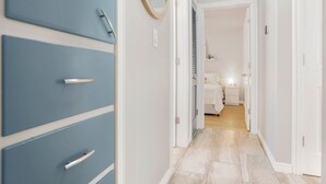 A hallway with a blue wardrobe, a mirror, and a door leading to a bedroom. - Lil' Love Shack ~ Private Yard (Loveland)