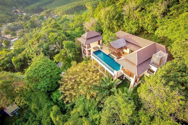 Aerial view of the villa nestled in the rainforest above the bay