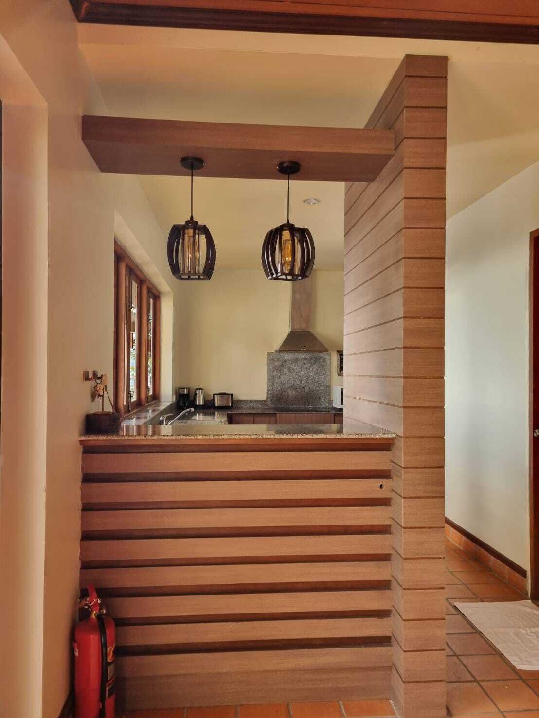 A kitchen with a stone countertop, hanging pendant lights, and a built-in stove.