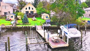 Una propiedad frente al agua con un muelle, una casa y un barco.