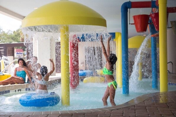 A water play area with multiple water jets and a pool.