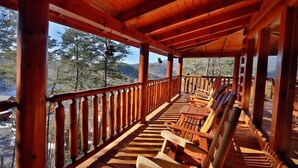 A wooden deck with a railing, wooden benches, and a view of trees and mountains. - Spacious 4BR Cabin w/ Game Room, Hot Tub & Pools – 3 Miles to Parkway (Sevierville)