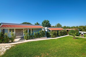 A row of modern houses with red-tiled roofs, surrounded by well-maintained lawns and small trees. - Mobile Homes with Shared Pool Rocco 2 (Medulin)