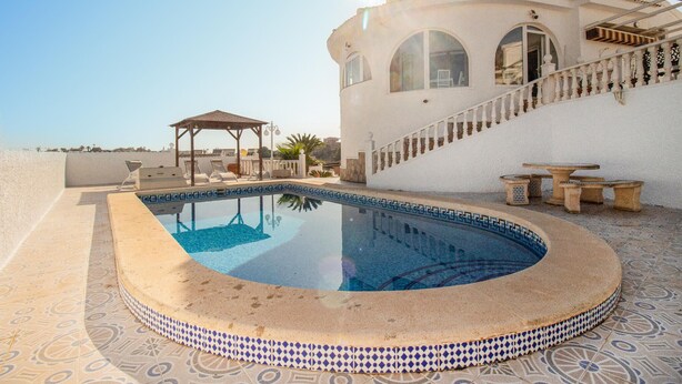 A swimming pool with a sunken deck, a covered seating area, and a staircase leading to a building with arched windows. - Awesome home in Ciudad Quesada (Ciudad Quesada)
