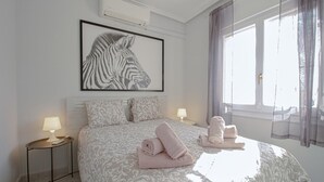 A bedroom with a large bed, two bedside tables, a framed zebra artwork, and a window with curtains. - Awesome home in Ciudad Quesada (Ciudad Quesada)