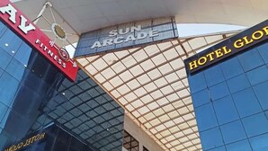 Un edificio moderno con una amplia fachada de vidrio, un letrero que indica gimnasio y un letrero de hotel.
