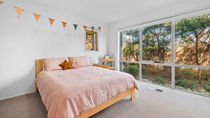 A bedroom with a large window, a bed, a bedside table, and a wall-mounted shelf. - Ocean Haven: 3  BR, 3  BA House in Sorrento, Sleeps 6 (Sorrento)
