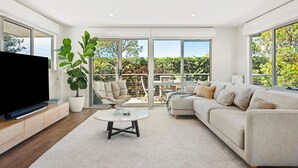 A spacious living room with a large TV, comfortable seating, a coffee table, and a potted plant. - Ocean Haven: 3  BR, 3  BA House in Sorrento, Sleeps 6 (Sorrento)