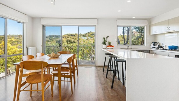 A modern kitchen with a large island, wooden dining table, and chairs. - Ocean Haven: 3  BR, 3  BA House in Sorrento, Sleeps 6 (Sorrento)