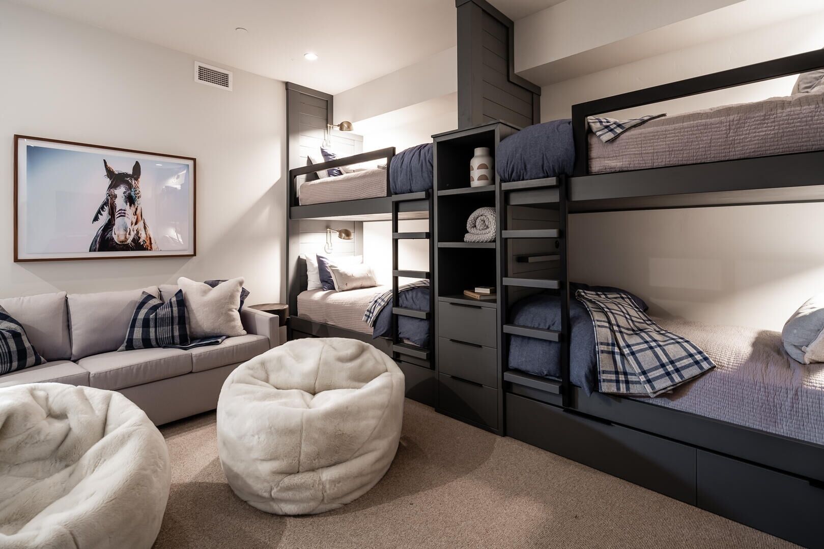 A modern bedroom with bunk beds, a sofa, and a bean bag chair.