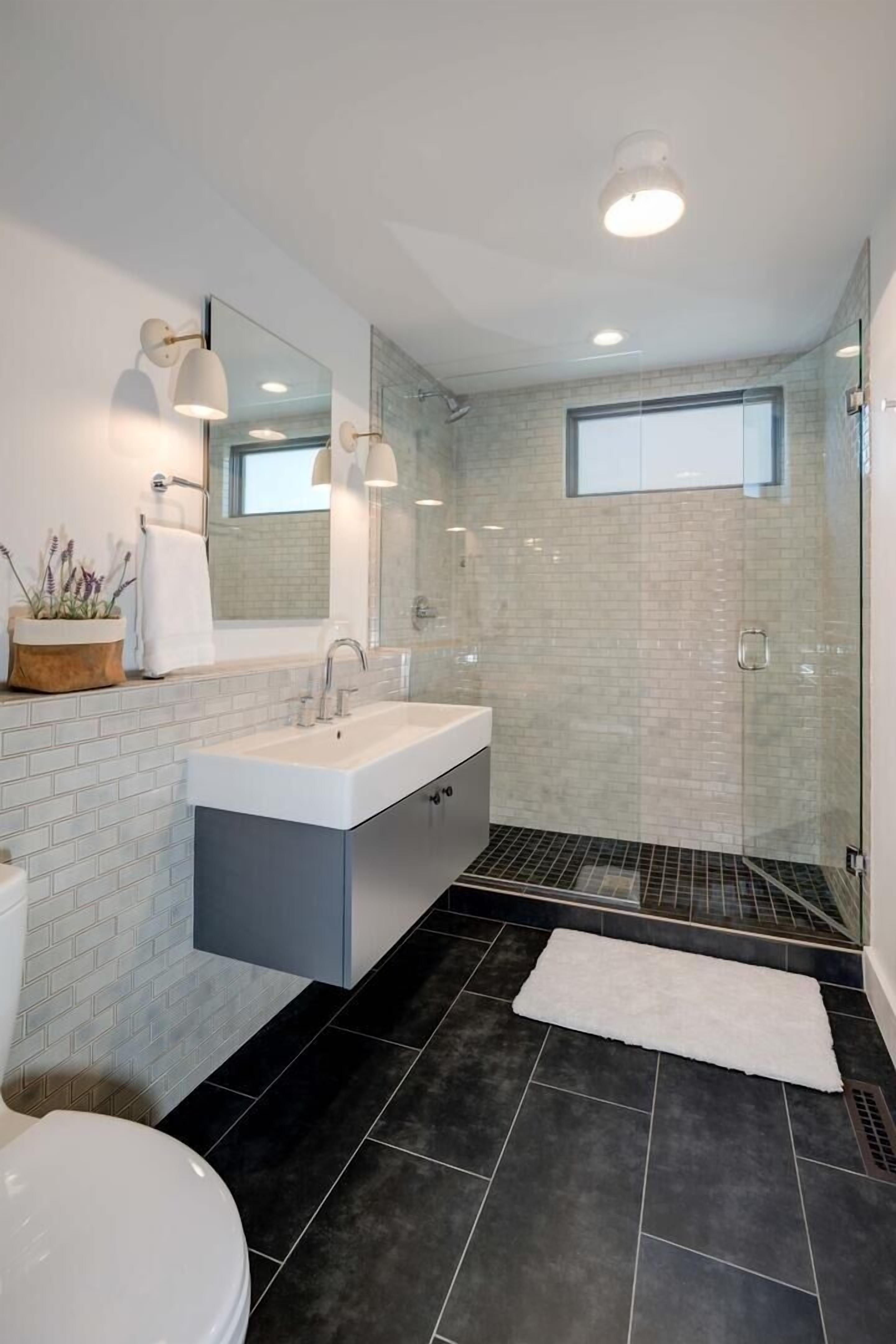 A modern bathroom with a white sink, a large mirror, and a glass shower enclosure.