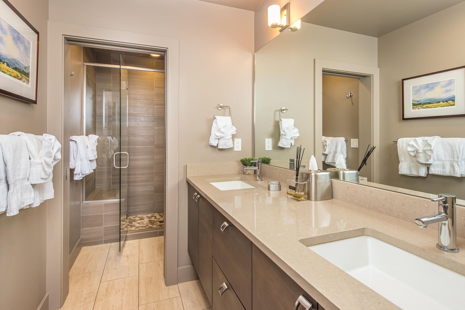 A modern bathroom with a glass shower enclosure, a double sink vanity, and a large mirror.