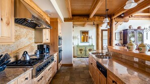 A kitchen with wooden cabinets, a stove, and a sink.