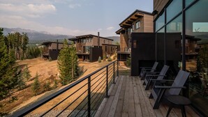 A modern building with a deck and outdoor seating.