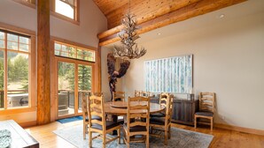 Un vaste espace dédié à la salle à manger, avec des meubles en bois, une grande fenêtre et une vue sur l’extérieur.
