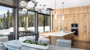 Une cuisine moderne avec des meubles en bois, un îlot central et des appareils électroménagers en acier inoxydable.