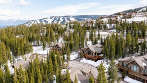 A mountain lodge with multiple cabins surrounded by snow-covered terrain and dense forests. - 6 Mountain Home Road 4 Bedroom Home by Moonlight Basin Lodging (Big Sky)