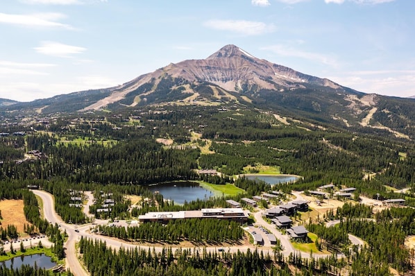 A mountain resort with multiple buildings, roads, and a lake.