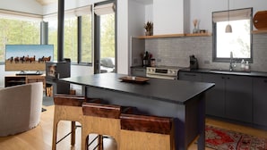 A modern kitchen with a central island, built-in appliances, and large windows. - 27 Lake Cabin 3 Bedroom Home by Moonlight Basin Lodging (Big Sky)