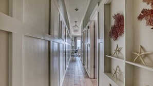 A long, narrow hallway with white walls and wooden flooring, leading to a room at the end. - FantaSea On 30A - Gulf View / Pickleball / Deeded Beach Access (Santa Rosa Beach)