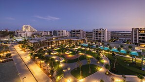 A resort with a swimming pool, landscaped areas, and modern buildings. - Sunset Gardens (Tserkezoi)