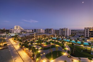Un resort con piscina, zonas ajardinadas y edificios modernos.
