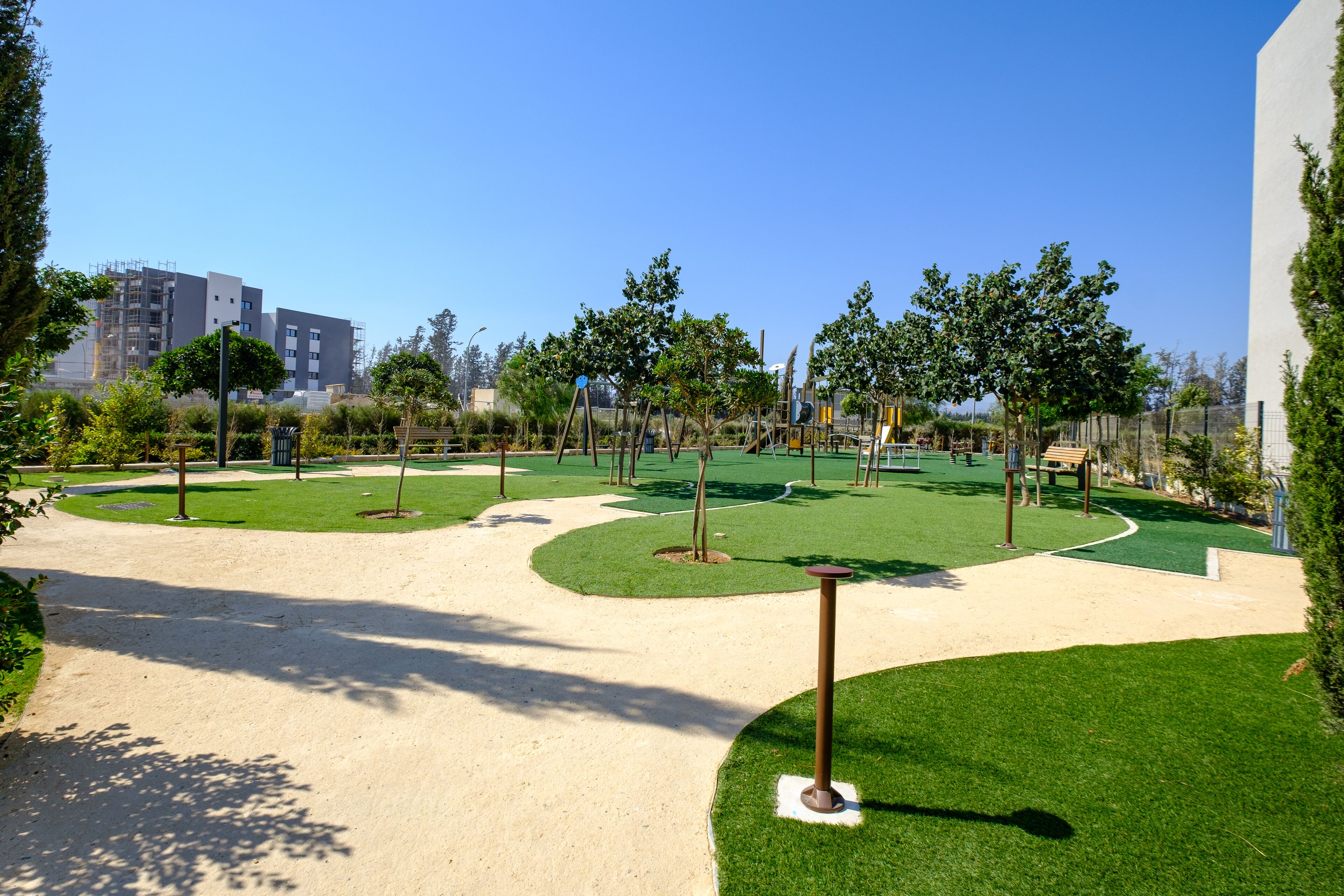 Ein angelegter Parkbereich mit Wegen, grünen Rasenflächen und Bäumen.