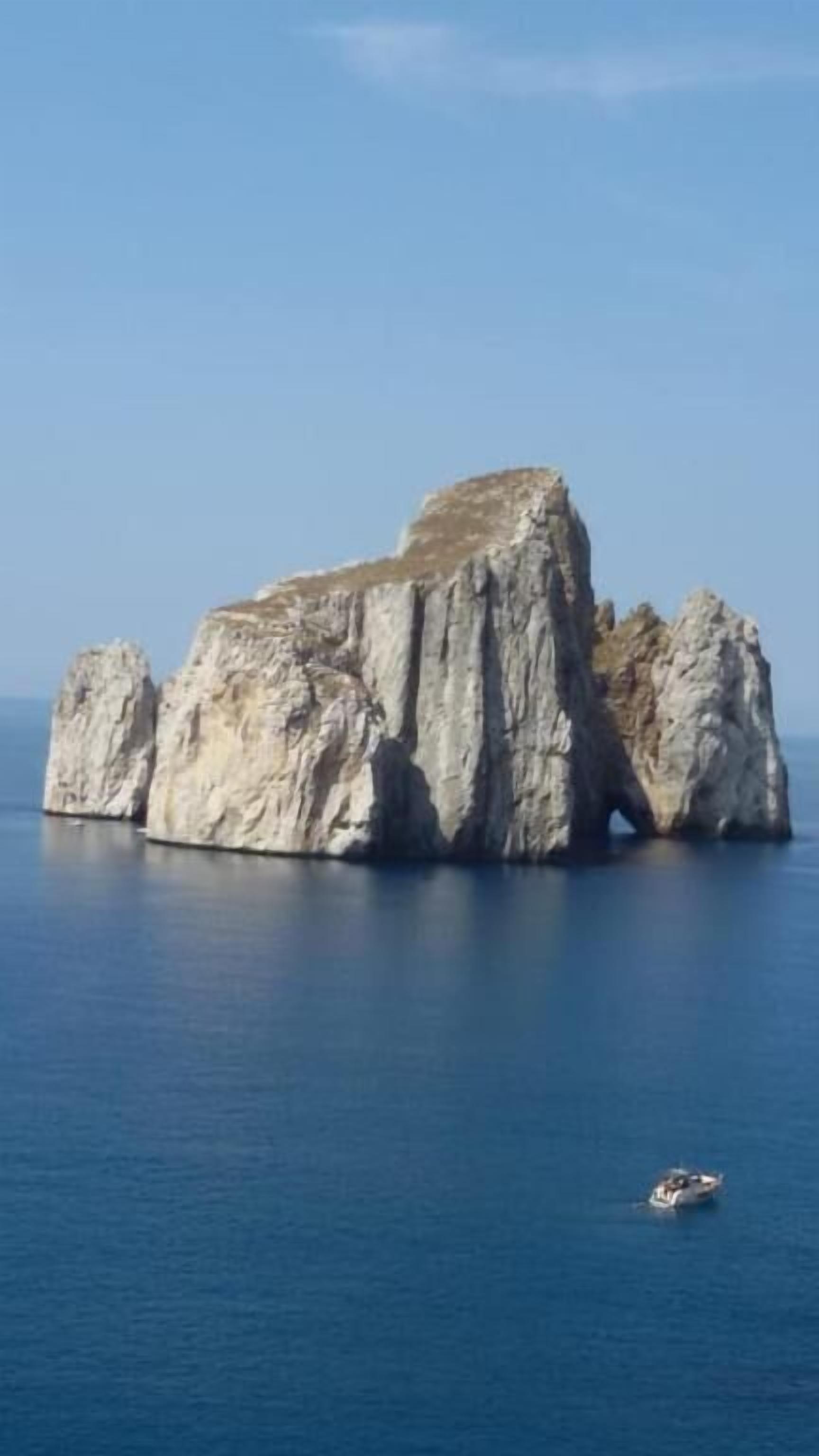 Una gran formación rocosa en aguas azul cristalino.