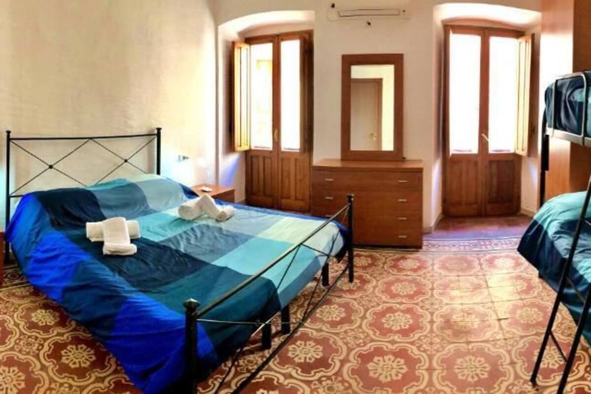 Un dormitorio con dos literas, un aparador de madera, un espejo y un suelo estampado.