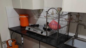 A small kitchen with a gas stove, a sink, and a tiled backsplash.