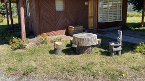 A rustic wooden cabin with a green roof, a wooden bench, and a table. - Patagonia Bordelago (Río Ibáñez)