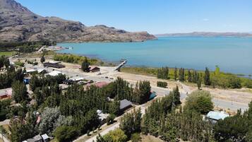 A coastal town with a marina, residential buildings, and a mountainous backdrop.