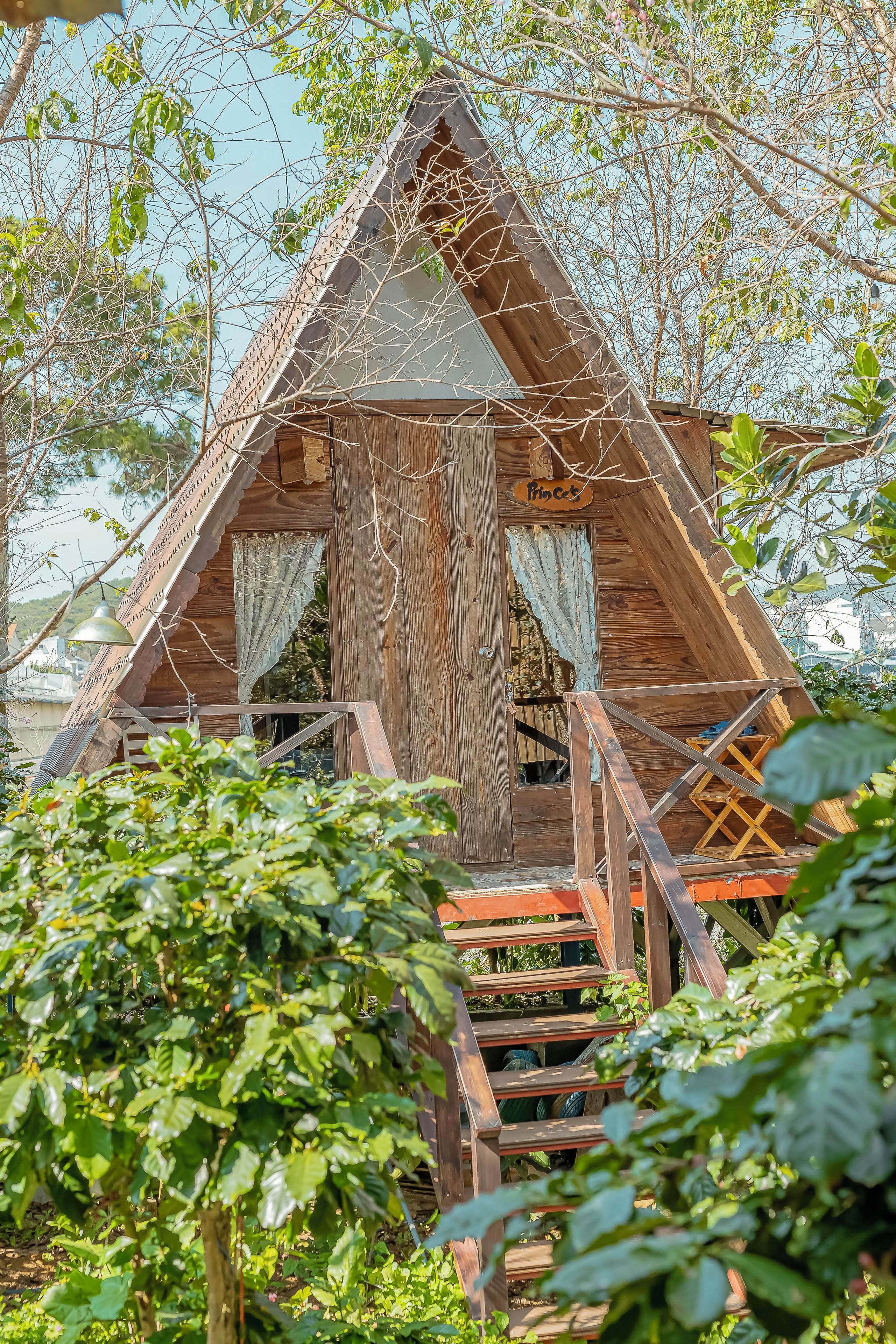 A wooden cabin with a triangular roof, a wooden staircase, and a sign that reads 'Princess.'