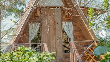 A wooden cabin with a triangular roof, a wooden staircase, and a sign that reads 'Princess.'