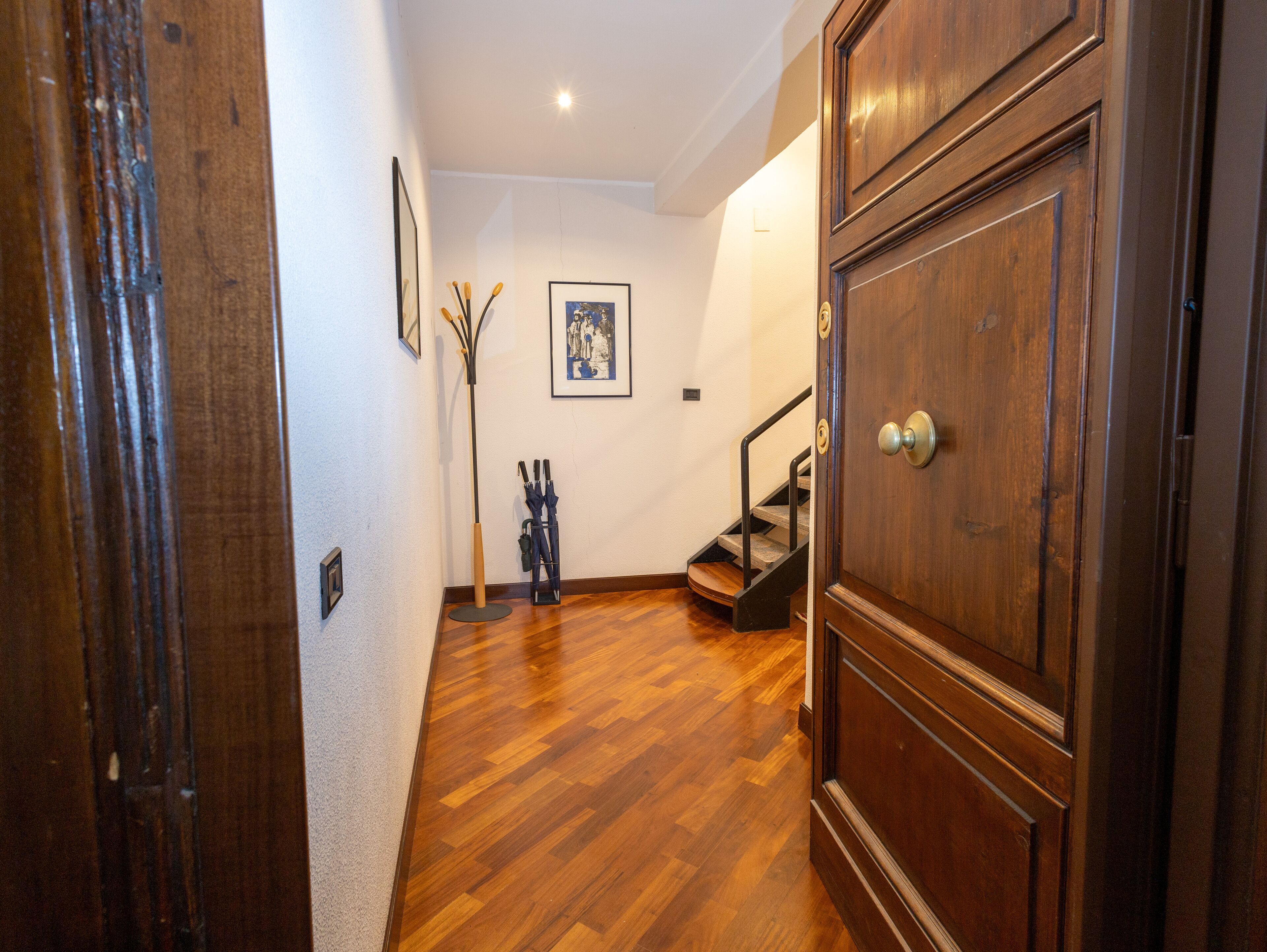 A wooden door, a staircase, and a framed picture on the wall.