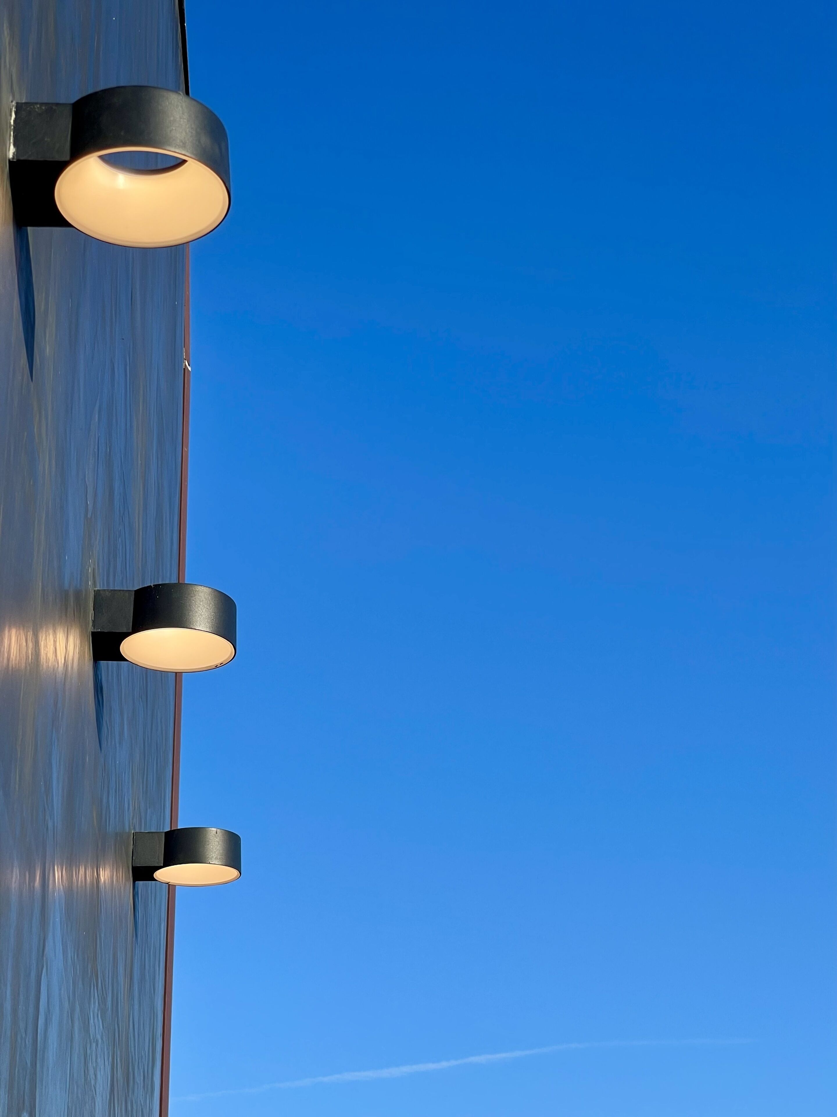A close-up of a wall with three circular light fixtures mounted on it.