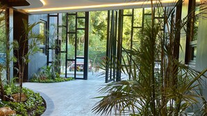 A modern indoor space with a curved pathway, large windows, and indoor plants. - OVA CANCUN Y TULUM (Tulum)