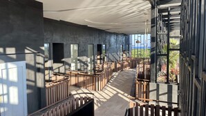 A modern interior with a curved staircase, large windows, and a view of greenery outside. - OVA CANCUN Y TULUM (Tulum)