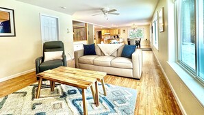 Un salon avec un canapé, un fauteuil, une table basse et un tapis.