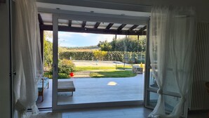 A room with a sliding glass door leading to an outdoor patio. - Lovely Portion of Villa in Ansedonia with swimming pool, 10' walk from Feniglia (Ansedonia)