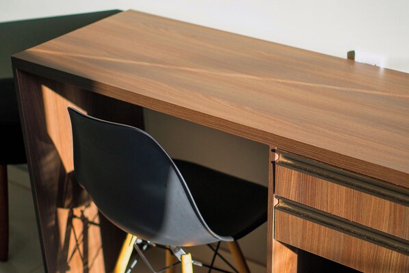 A wooden desk with a black chair. - Pinheiro Flat Hotel (Ibiapina)