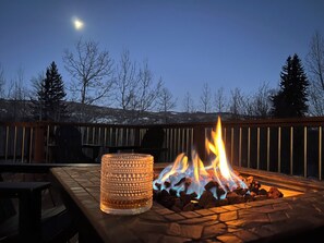 A patio area with a stone fire pit and a glass candle holder. - Incredible Views, Large Deck, Wood Burning Fireplace! Havland Lake 3bed/3bath (Durango)