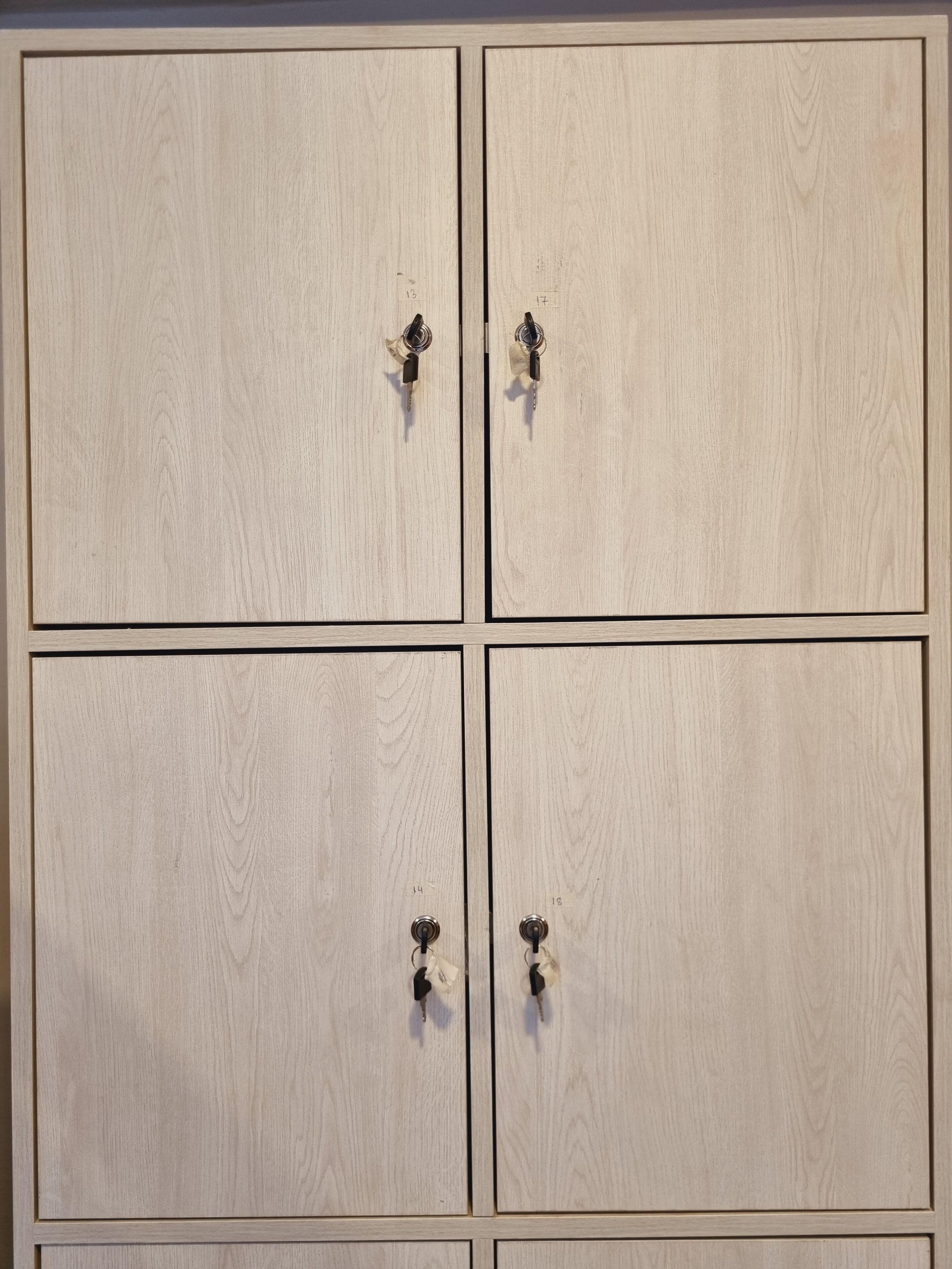 A set of four wooden cabinets with metal handles, each marked with a number.