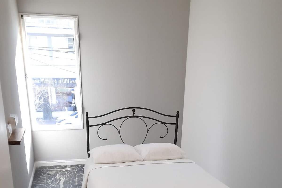 Ein Schlafzimmer mit einem Bett, einem Fenster und einer Tür.