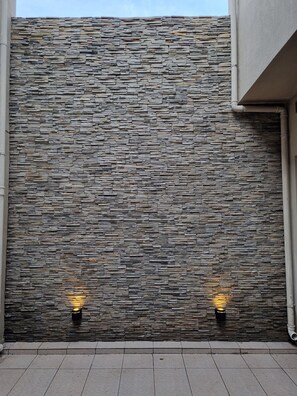 A stone wall with two wall-mounted lights.