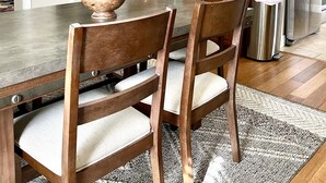 A dining area with a wooden table and chairs, a chandelier, and kitchen cabinets in the background. - “1933” Sleeps 6,  King Beds, Spacious, 5 min walk to downtown Mt. Dora  (Mount Dora)