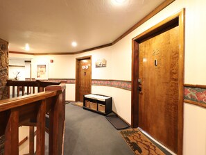 Traditional design features wooden doors, a reception desk, and a stone accent wall.
