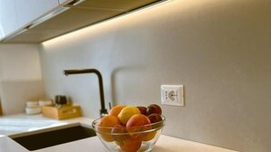 A modern kitchen with a stainless steel countertop, a bowl of fruit, and a visible electrical outlet. - Splendid "True Venice Apartment" overlooking water (Venezia)