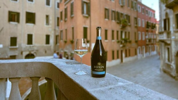 A bottle of Zonin Prosecco and a glass on a balcony overlooking a street with historic buildings. - Splendid "True Venice Apartment" overlooking water (Venezia)