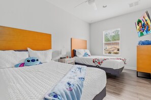 A hotel room with two beds, a window with a view, and a wall-mounted artwork.